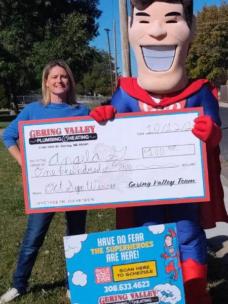 October yard-sign winner Angela G. with their Gering Valley Plumbing & Heating sign