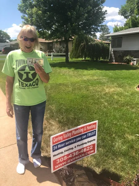 June yard-sign winner Becky with their Gering Valley Plumbing & Heating sign