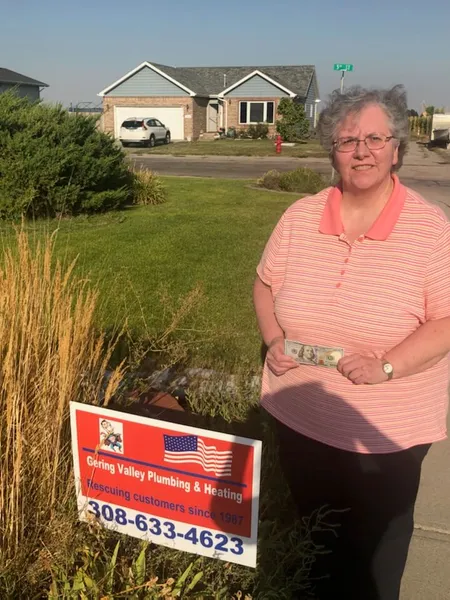 August yard-sign winner Laurie with their Gering Valley Plumbing & Heating sign