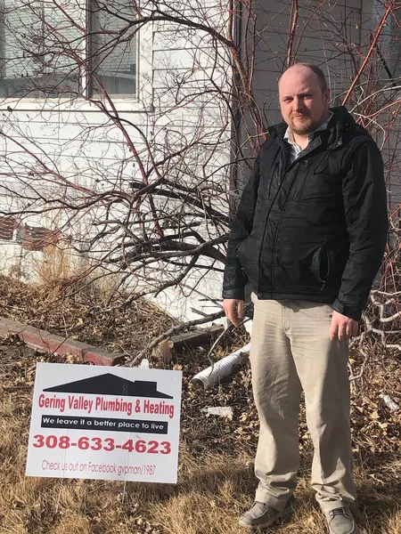December yard-sign winner Adam with their Gering Valley Plumbing & Heating sign
