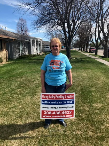 April yard-sign winner Connie with their Gering Valley Plumbing & Heating sign