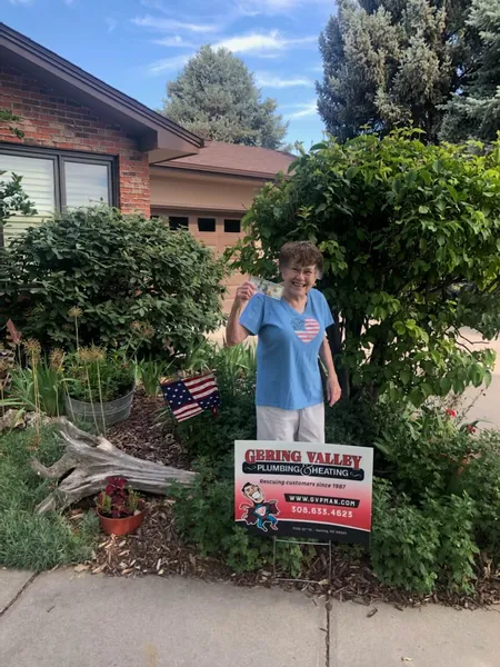 June yard-sign winner Claudette with their Gering Valley Plumbing & Heating sign