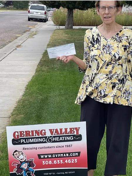 September yard-sign winner Joyce with their Gering Valley Plumbing & Heating sign