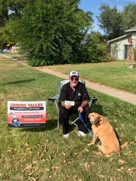 October yard-sign winner Tracey B and his dog Gwinny with their Gering Valley Plumbing & Heating sign