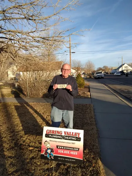 December yard-sign winner Garth Seifert with their Gering Valley Plumbing & Heating sign