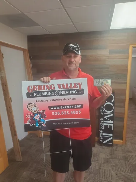 July yard-sign winner Russ K with their Gering Valley Plumbing & Heating sign