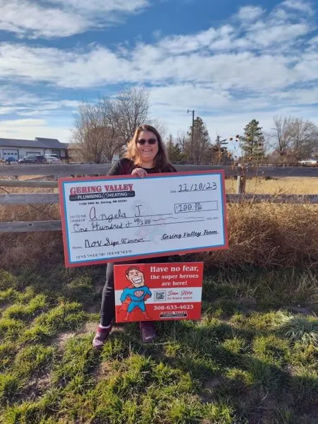 November yard-sign winner Angela J. with their Gering Valley Plumbing & Heating sign