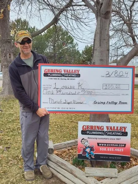 March yard-sign winner Lousie K. Accepted by Grandson Tim with their Gering Valley Plumbing & Heating sign