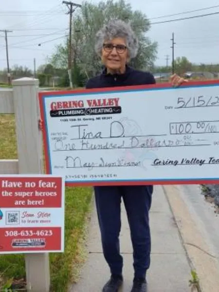 May yard-sign winner Tina D. with their Gering Valley Plumbing & Heating sign