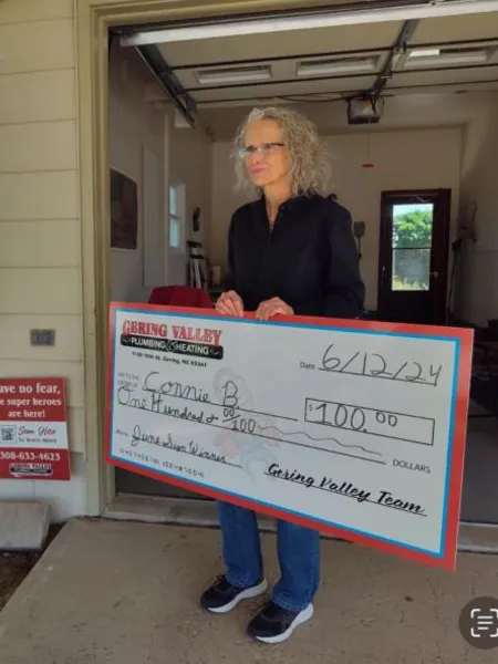 June yard-sign winner Connie B. with their Gering Valley Plumbing & Heating sign