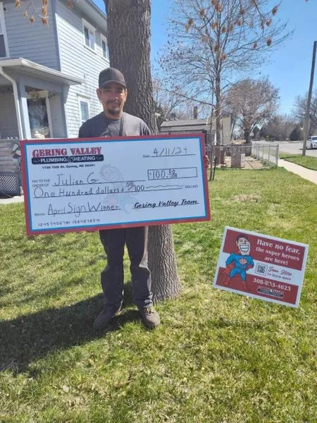 April yard-sign winner Julian G. with their Gering Valley Plumbing & Heating sign